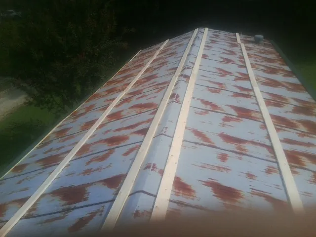 Rusted metal roof panels with new wood purlins before replacement — Storm Damage Roof Repair in Ernul by Roofing Brothers