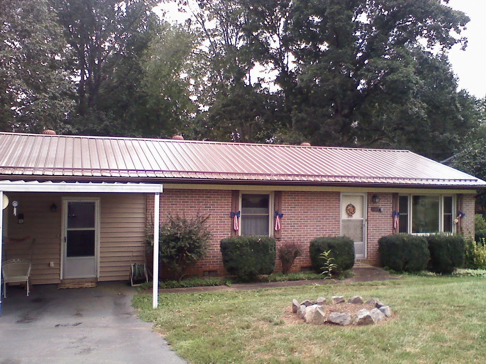 Bronze metal roof and carport on a brick ranch home — Roof Repair work by our crew in Ernul
